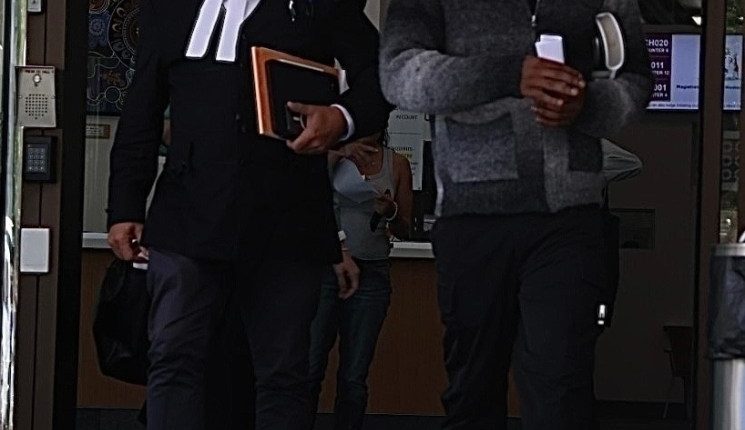 Yung Filly leaving a courthouse with his lawyer.