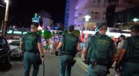 Guardia Civil officers patrolling a street at night.