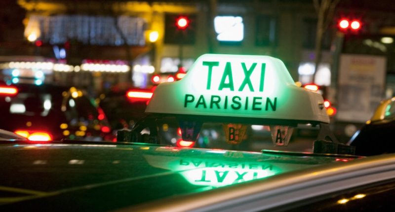 Taxi Parisien sign on a taxi at night.