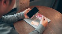 Man using phone and credit cards for online banking.
