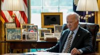 President Biden sitting at his desk in the Oval Office.