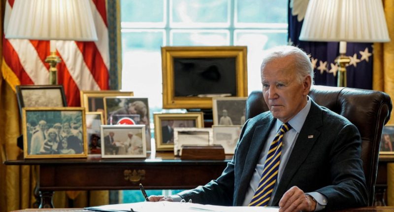 President Biden sitting at his desk in the Oval Office.