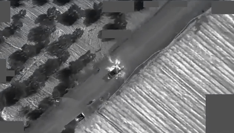 Aerial thermal image of a vehicle explosion on a road.