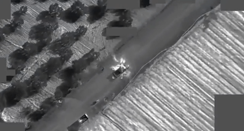 Aerial thermal image of a vehicle explosion on a road.
