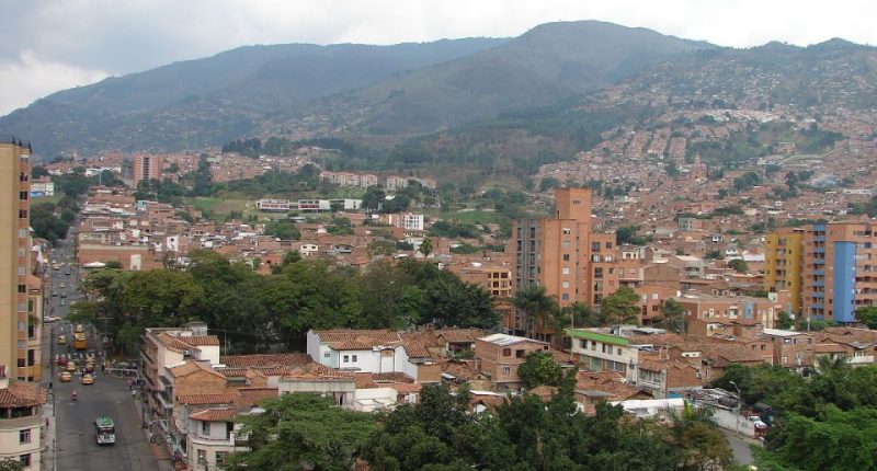 Aerial view of a city nestled in mountains.