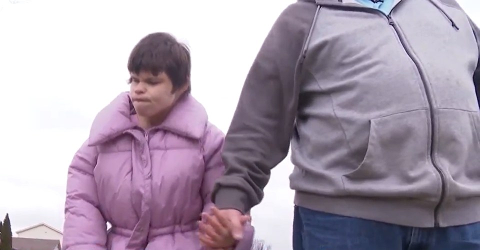 A disabled woman and a man holding hands.