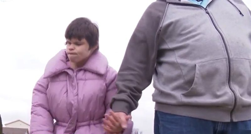 A disabled woman and a man holding hands.