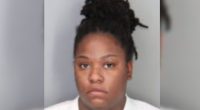 Mugshot of a woman with dark hair in a bun.