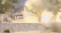 Blurry image of a stone wall and buildings.