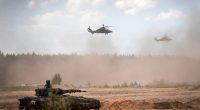German Army Eurocopter Tigers flying over a tank during a military exercise in Lithuania.