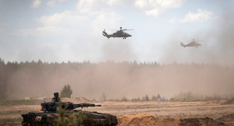 German Army Eurocopter Tigers flying over a tank during a military exercise in Lithuania.