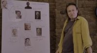 Person standing next to whiteboard identifying potential Bitcoin creators.