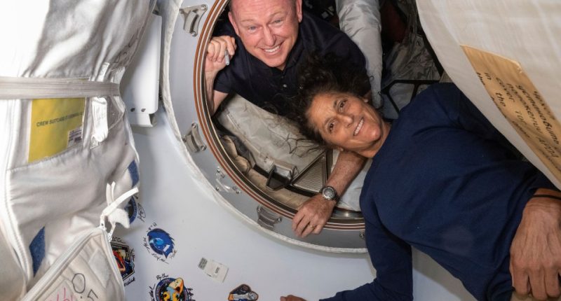 Two astronauts in the International Space Station's vestibule.