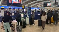 Crowded Heathrow Airport terminal with passengers checking in.