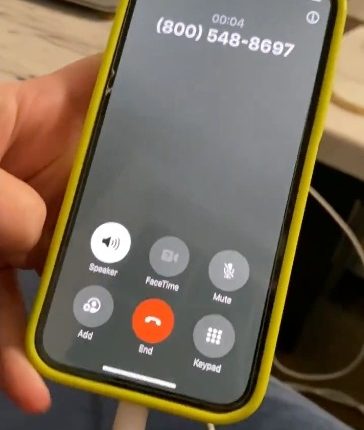 Smartphone displaying an incoming call from a sex hotline number.