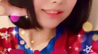 Screenshot of a woman in a red and blue jersey, making a heart shape with her hands.  Japanese text overlays the image.
