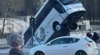 A bus has reversed into a river, striking a car and pedestrians.
