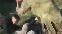 A soldier apprehending a person on the ground.