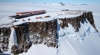 Aerial view of SANAE IV research base on a cliff in Antarctica.