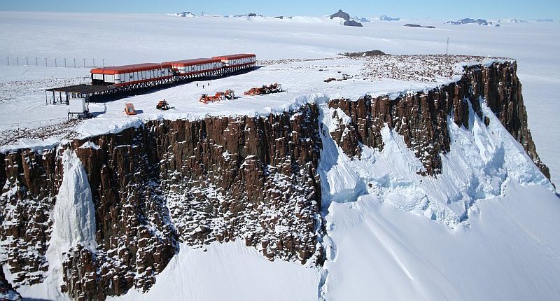 Aerial view of SANAE IV research base on a cliff in Antarctica.