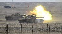 Romanian army tanks firing during a NATO military exercise.