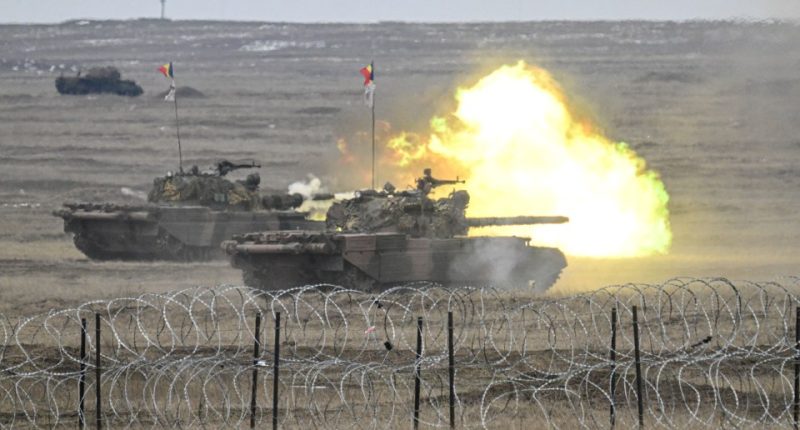Romanian army tanks firing during a NATO military exercise.