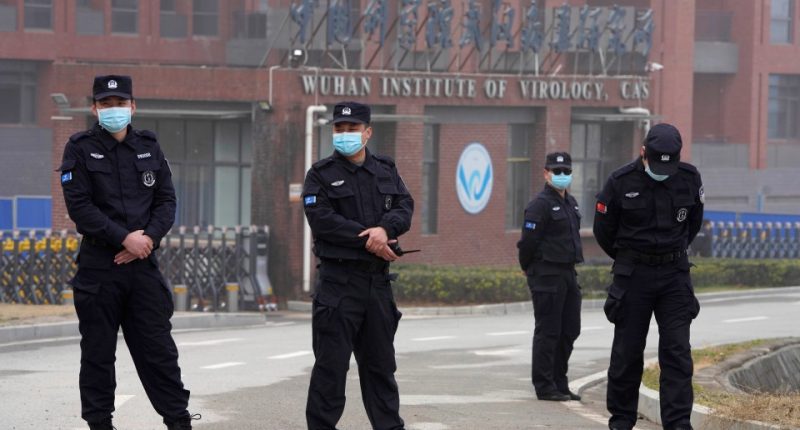 Security personnel in face masks stand outside the Wuhan Institute of Virology.