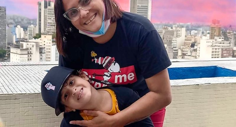 Raphael Batista and his son Gustavo pose on a rooftop.