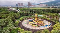Aerial view of an abandoned water park overgrown with vegetation.