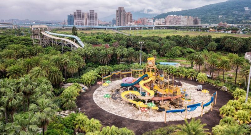 Aerial view of an abandoned water park overgrown with vegetation.