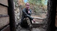 Woman sitting in a wooden trench.