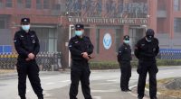 Security personnel in face masks stand outside the Wuhan Institute of Virology.