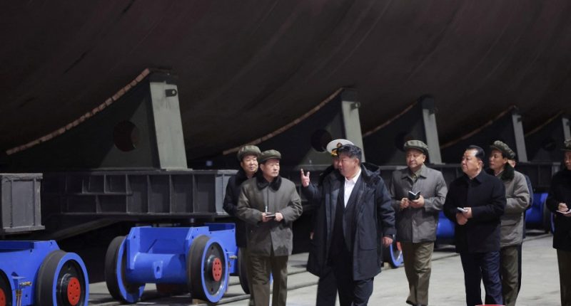 Kim Jong Un inspecting a nuclear submarine under construction.