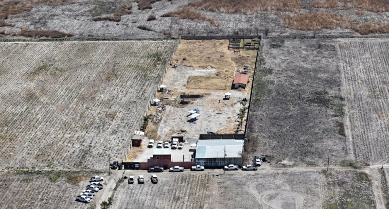 Aerial view of a crime scene in Mexico, showing vehicles and personnel from law enforcement agencies at a ranch where human crematoriums were discovered.