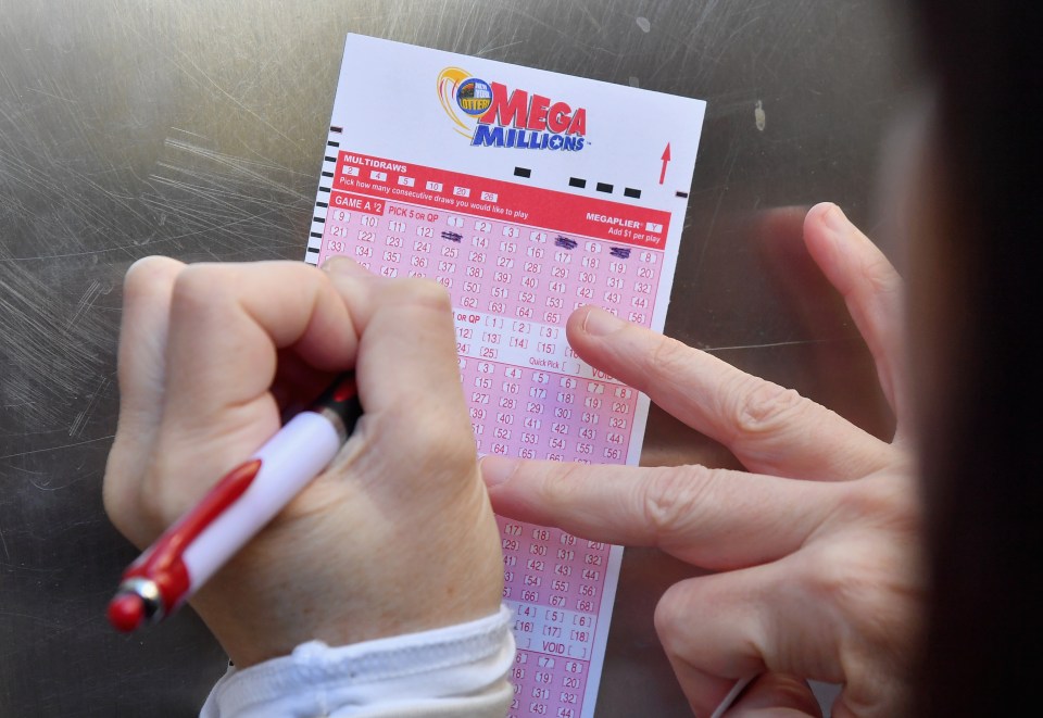 Person filling out a Mega Millions lottery ticket.