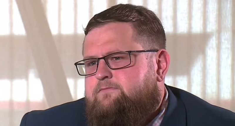 A man wearing glasses and a suit.