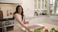Meghan Markle in a kitchen, smiling.