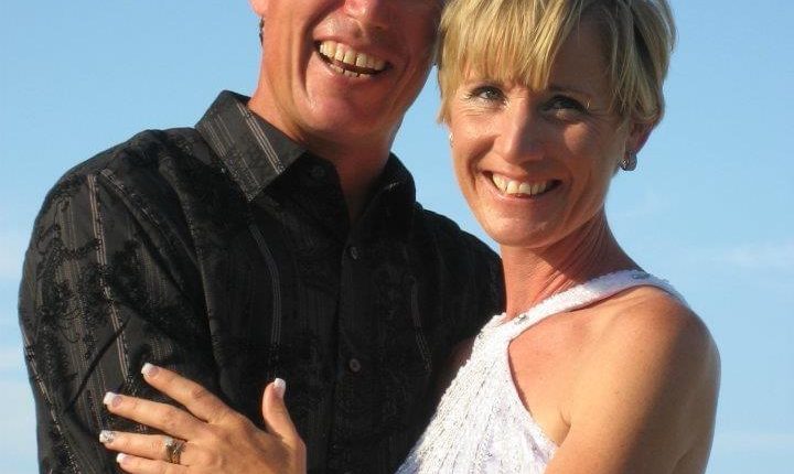 Portrait of a smiling couple embracing outdoors.