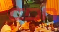 Blurry image of people seated at a table, possibly in a restaurant.