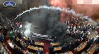 Serbian opposition lawmakers using flares and tear gas in parliament during anti-corruption protests.