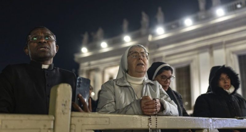 Catholic faithful attend a nightly rosary prayer for the health of Pope Francis in St. Peter's Square at the Vatican, Sunday, March 2, 2025. (AP Photo/Mosa'ab Elshamy)