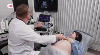 A doctor performing an ultrasound on a pregnant woman.