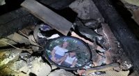 Clock with family photo in debris of destroyed house.