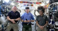Three astronauts in the International Space Station give a news conference.