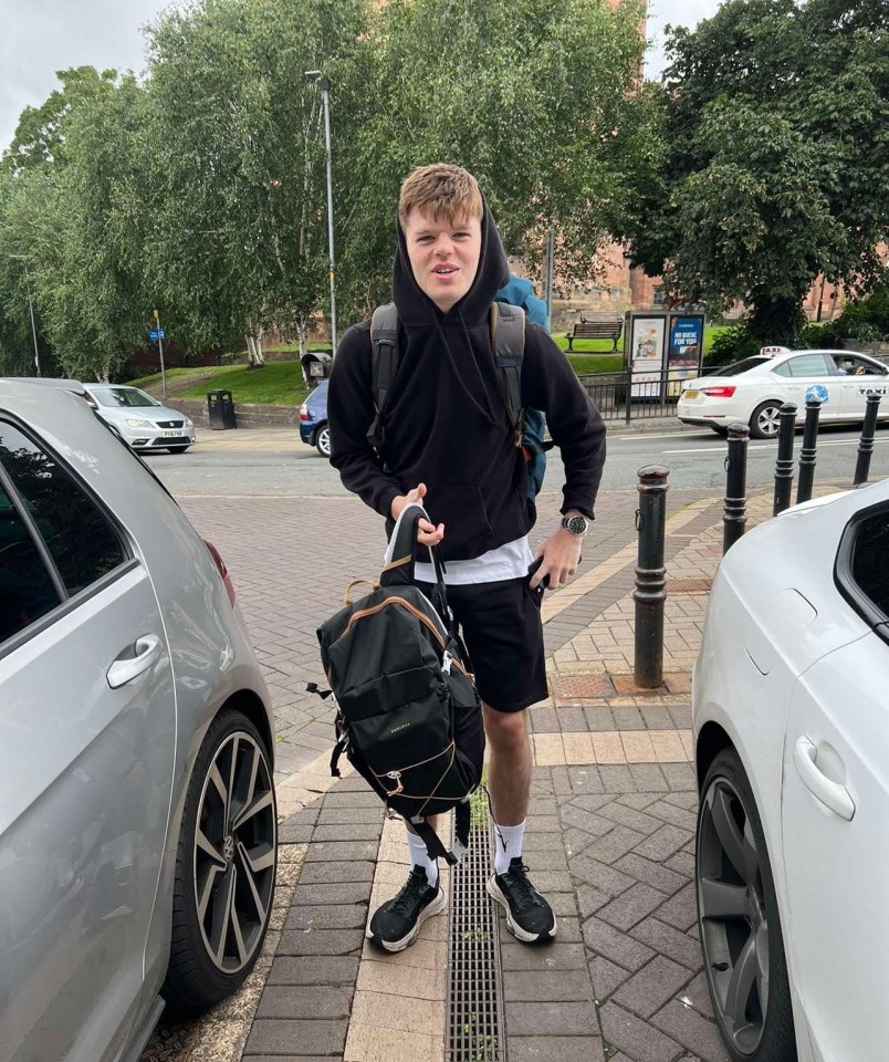 Owen Haggerty, a Royal Navy sailor, stands on a sidewalk with a backpack.