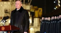 Vladimir Putin speaking at a podium.