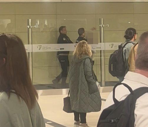 Police officers subduing a disruptive passenger at an airport.