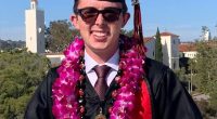 Graduate in cap and gown wearing a lei.
