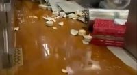 Flooded galley kitchen with spilled food and broken dishes.