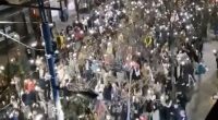 Protesters in Belgrade reacting to a sound during a demonstration.